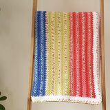 the handmade baby blanket folded over a large wooden ladder