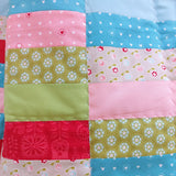 pink wavy lines of quilting stitches on the intersections of the rectangular patches