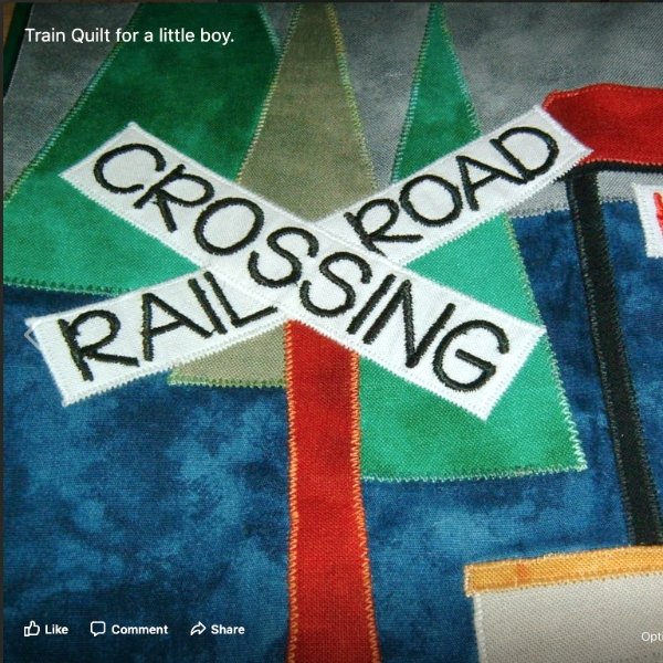 a sign on a railway quilt saying rail road crossing. The sign sits in front of trees and a mountain.
