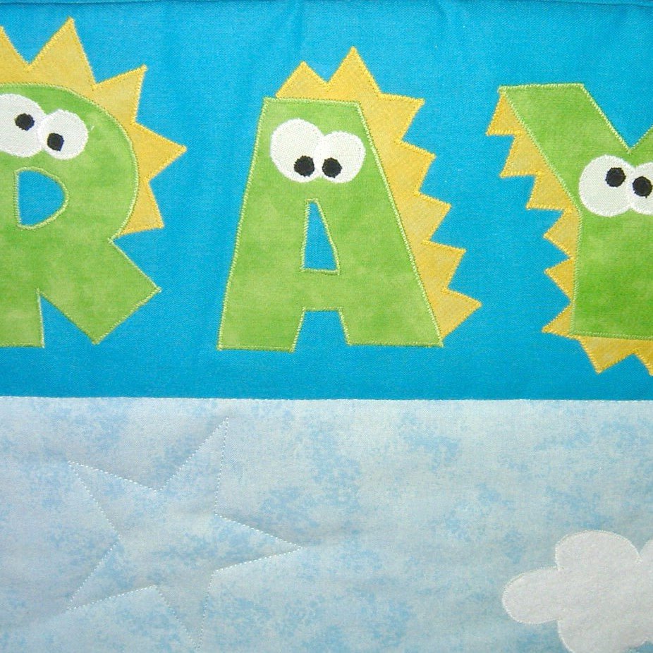 the name ray in green letters with yellow dinosaur spikes and eyes on each letter