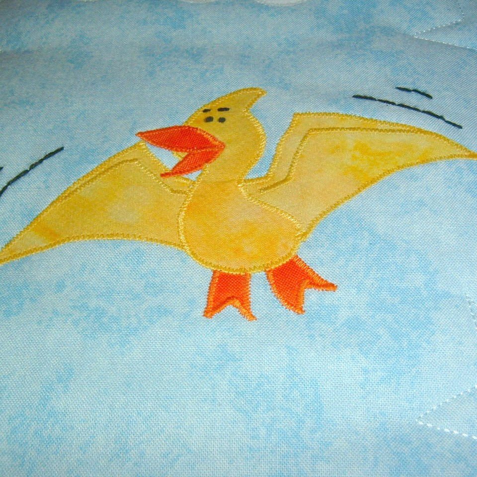 a flying yellow and orange bird in a blue sky