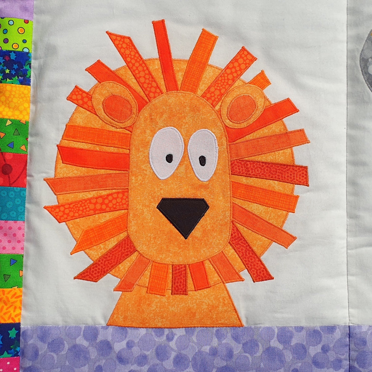 bright orange lion on a jungle quilt with big white eyes and black nose 