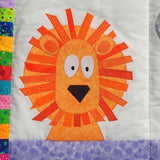 bright orange lion on a jungle quilt with big white eyes and black nose 