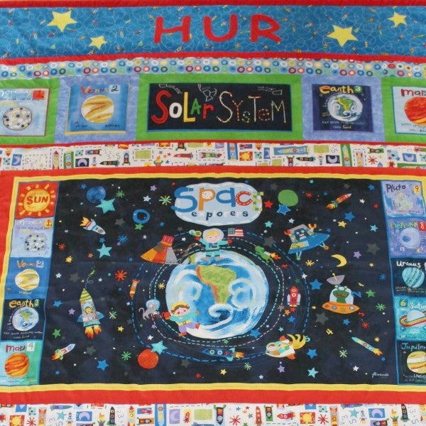toddler quilt showing a pre-printed cotton panel of the dark atmosphere with the earth in the centre surrounded by planets.