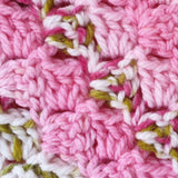 close up of the pink and green stitch on the handmade crochet baby blanket