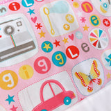 part of a pink quilt with all things girl printed on it for example cars, butterflies, stars and the word giggle