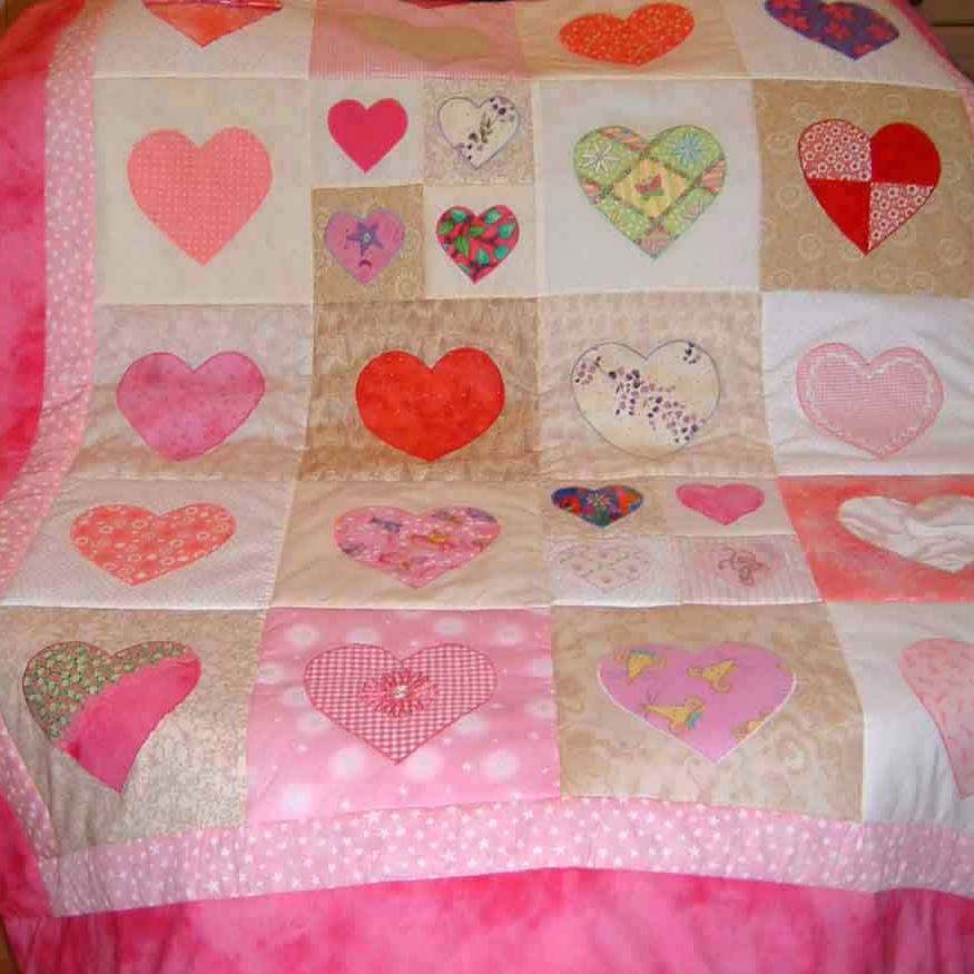 pastel pink hearts on a patchwork quilt