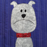 a plain purple background has a grey dog with a red and stars collar. The dog looks grumpy with his mouth turned down.