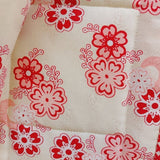a close up of the back of the quilt which is a cream fabric covered in pink and red flowers