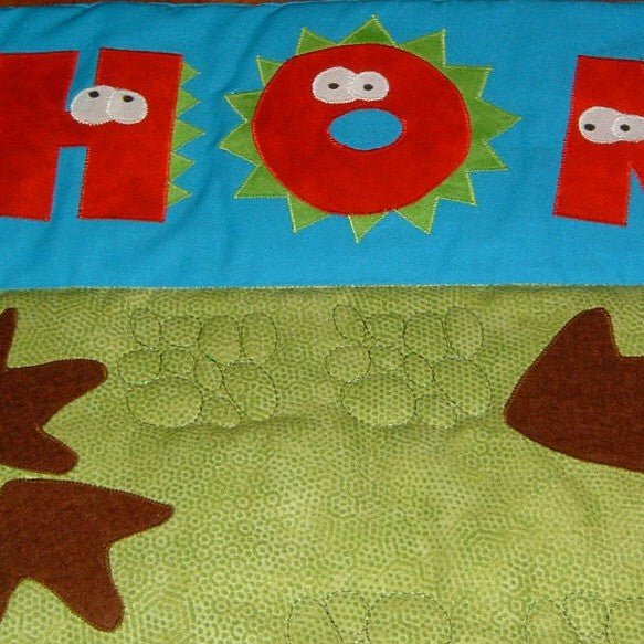 close-up of the quilting on the green dinosaur quilt showing a pebble motif