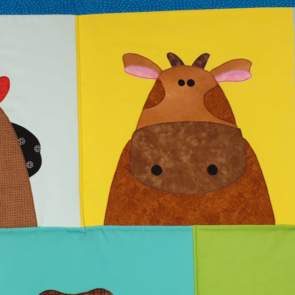 A brown cow on a yellow background of the farm quilt